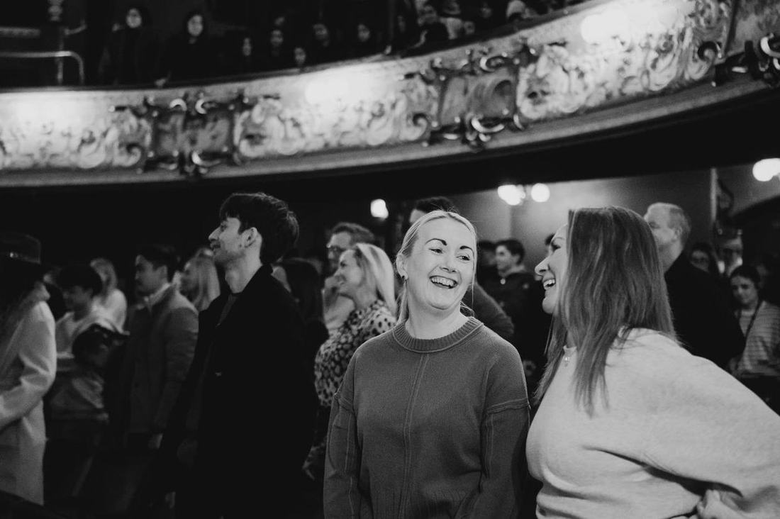 The audience, mid-laugh.