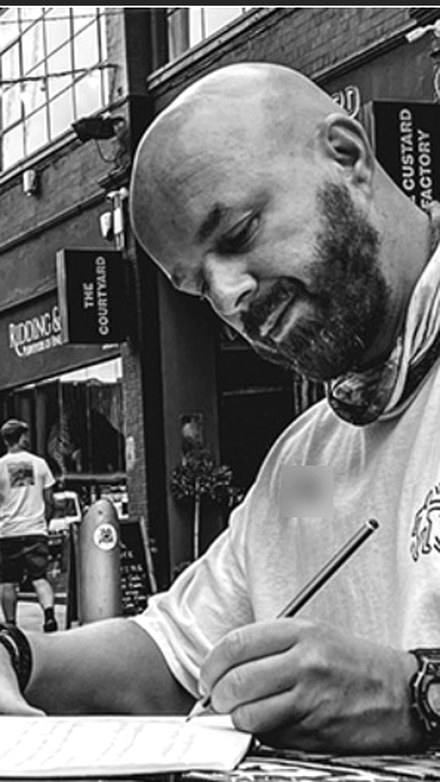 Luke Staton writing at a cafe table.